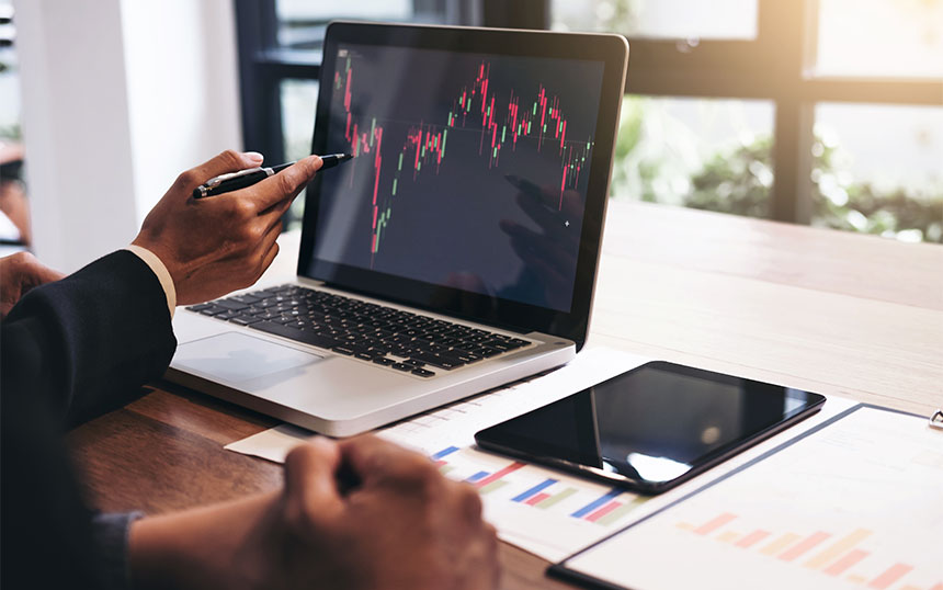 Man pointing out charts on laptop